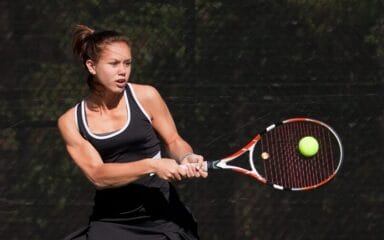 NCAA student playing tennis